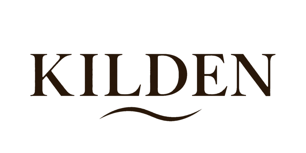 Designet på KILDEN-capsen: ordet KILDEN med et bølgeornament under