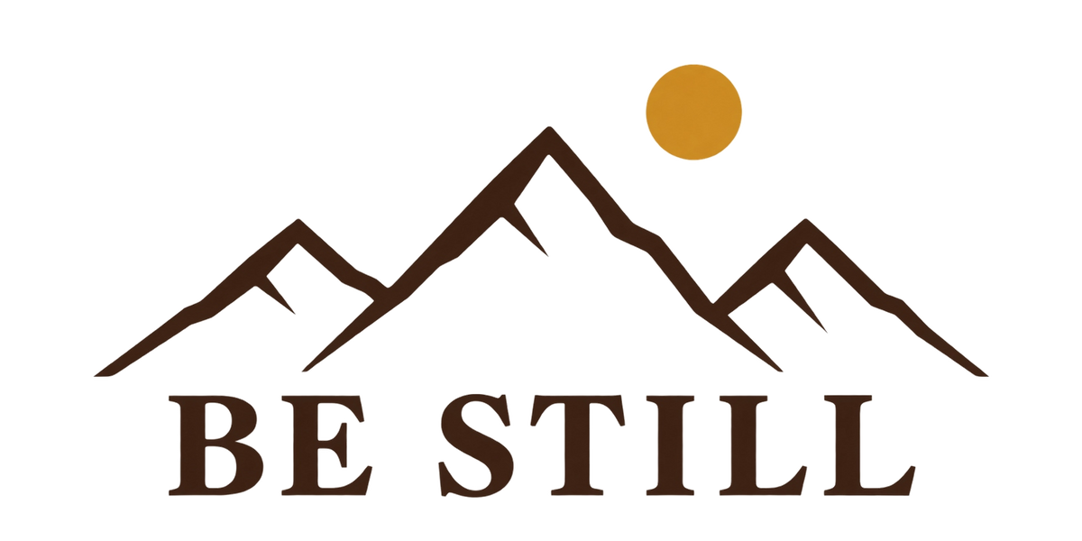 Designet på Be Still-capsen: BE STILL under en fjellsilhuett og en gyllen sol