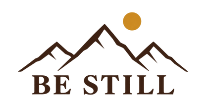 Designet på Be Still-capsen: BE STILL under en fjellsilhuett og en gyllen sol